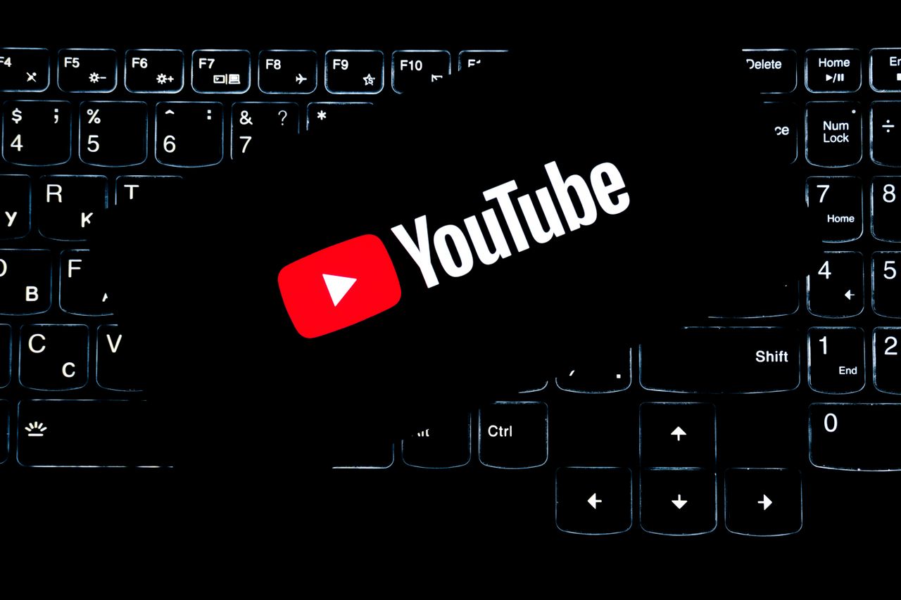 A YouTube logo shown on a backlit keyboard, symbolizing digital media and online content creation.